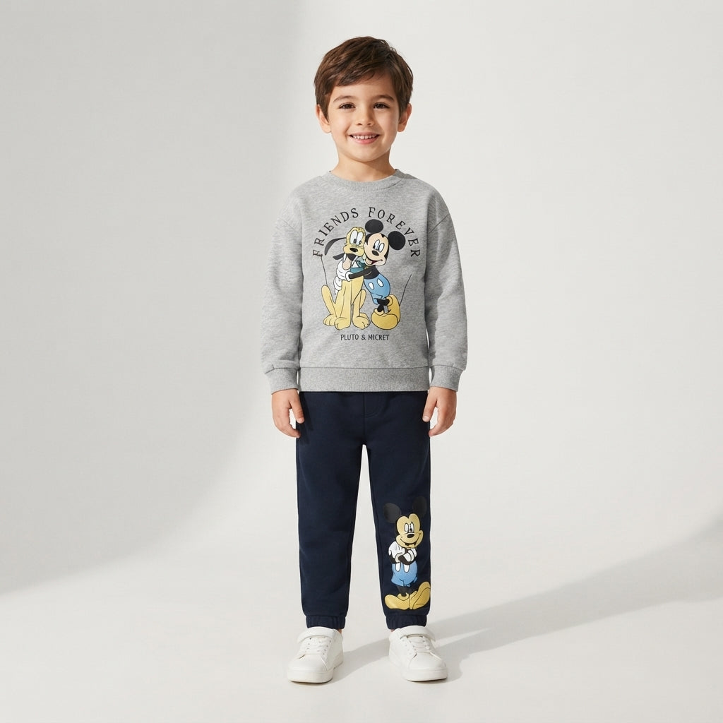 Niño vistiendo pantalón de chándal azul marino EmpiBy con estampado de Mickey Mouse y sudadera gris a juego