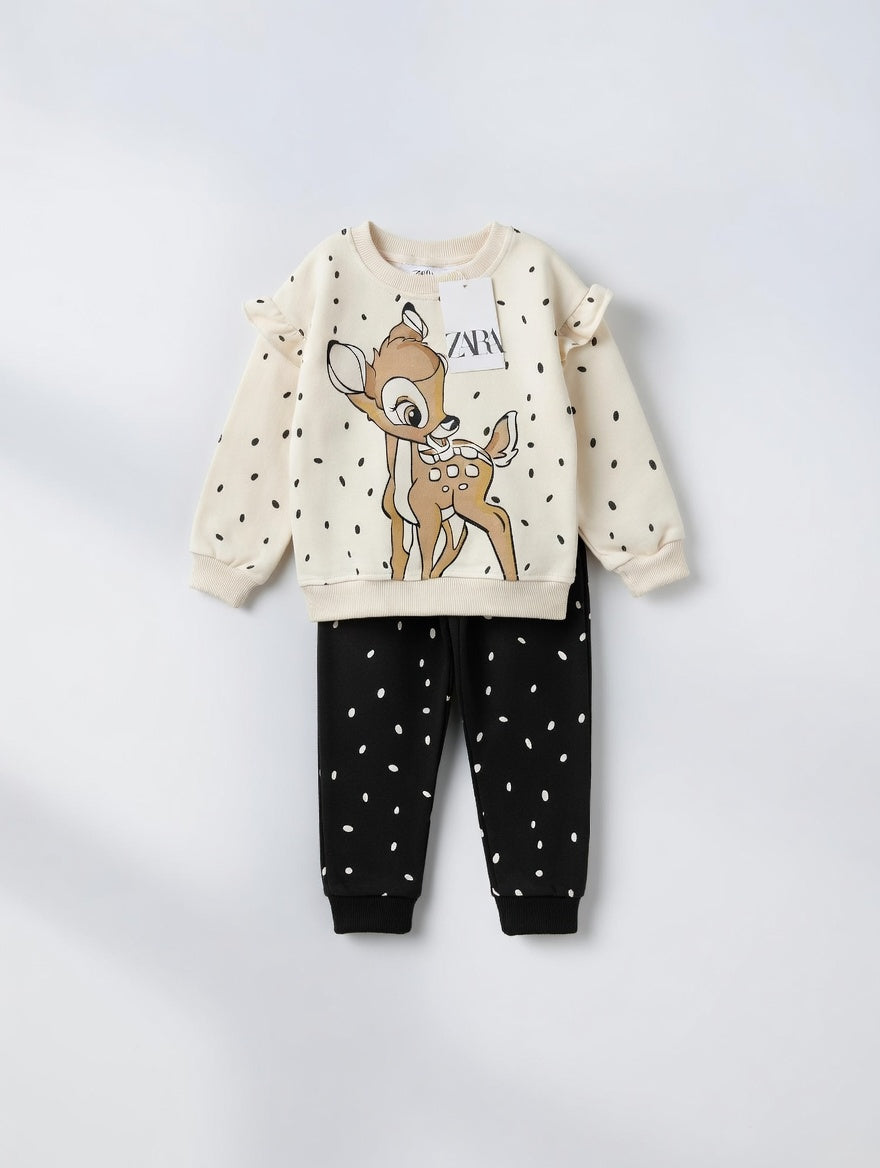 Conjunto EmpiBy para niña con sudadera color crema de Bambi y pantalón negro con estampado de puntos