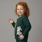 Niña pelirroja sonriendo con sudadera verde EmpiBy de Bambi y Tambor con estampado de lunares