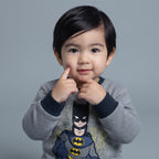 Bebé con sudadera gris EmpiBy de Batman con estampado frontal y cuello azul marino, estilo casual y cómodo.