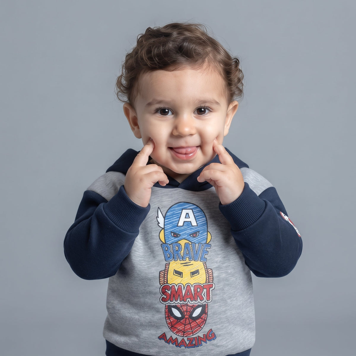 Bebé sonriente vistiendo sudadera EmpiBy gris y azul marino con estampado de superhéroes Marvel y capucha