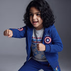 Niño posando con conjunto EmpiBy de Capitán América, sudadera azul con capucha, camiseta gris y pantalón jogger