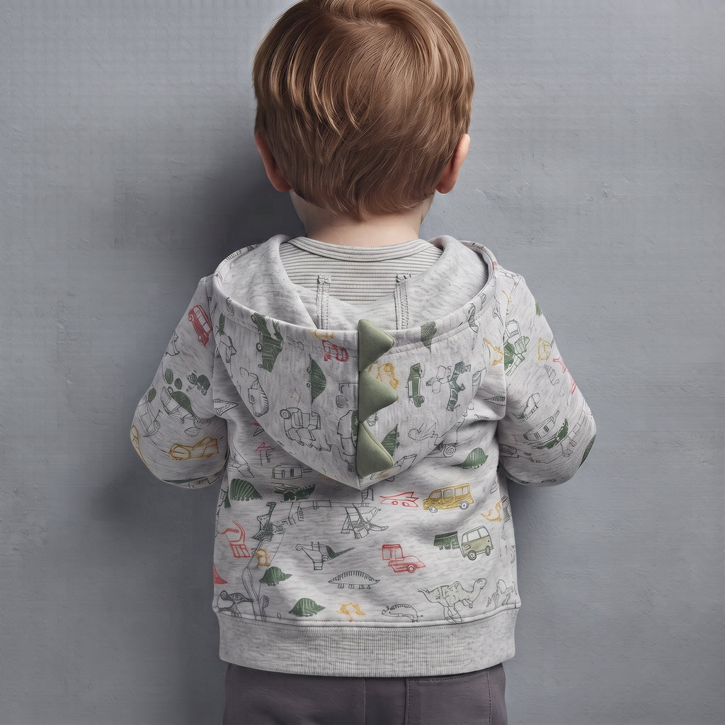 Niño de espaldas vistiendo chaqueta gris con capucha de dinosaurio y estampado colorido de EmpiBy