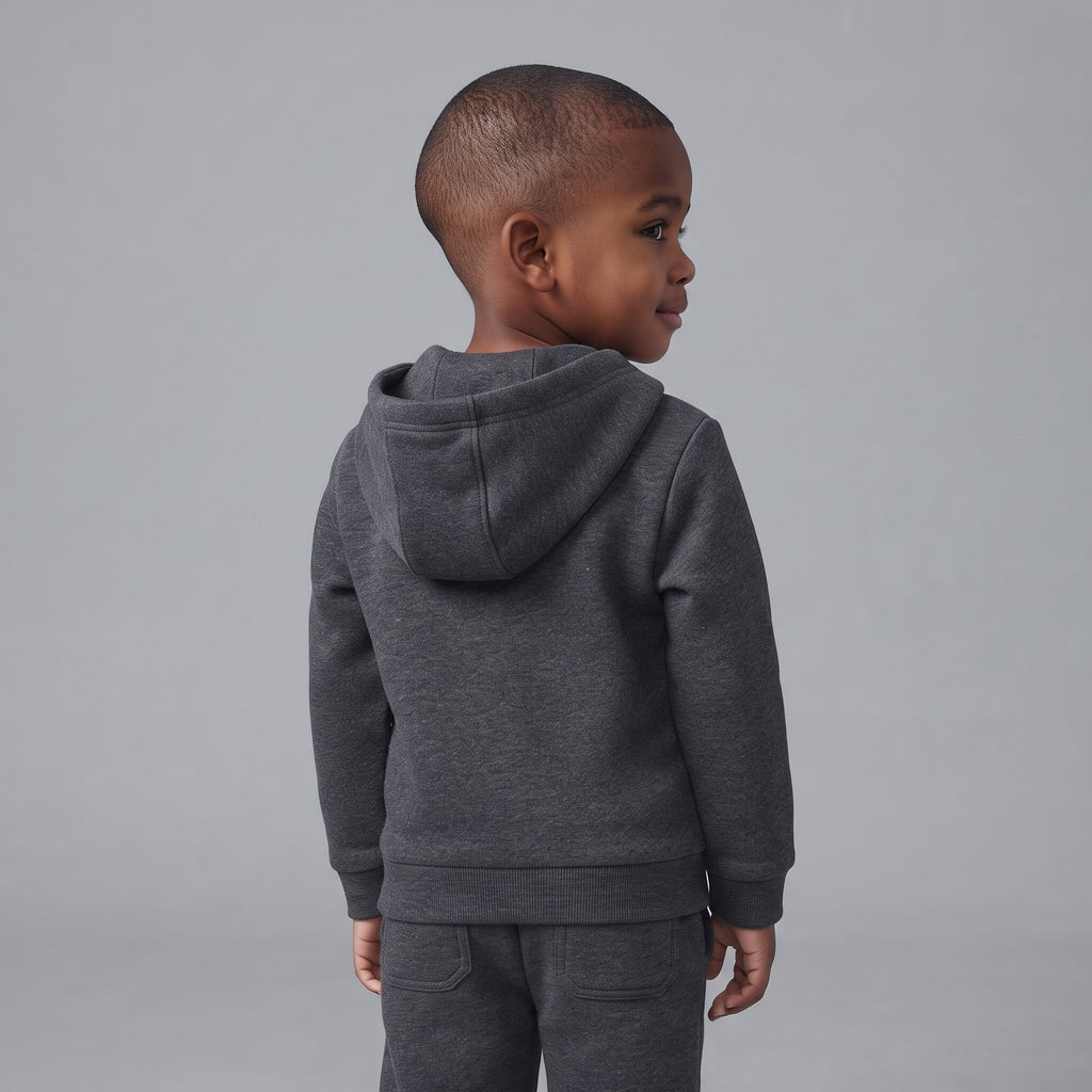 Niño de espaldas vistiendo sudadera con capucha y pantalón jogger gris oscuro de EmpiBy con temática de Disney