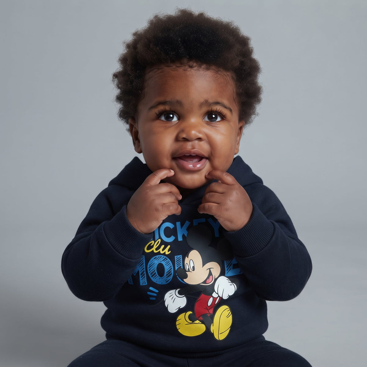 Bebé con sudadera azul marino de Mickey Mouse de EmpiBy, con capucha y gráfico frontal, estilo cómodo y moderno.