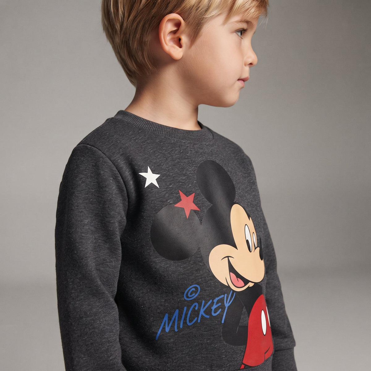 Niño vistiendo sudadera gris EmpiBy con estampado de Mickey Mouse y estrellas, estilo casual y cómodo