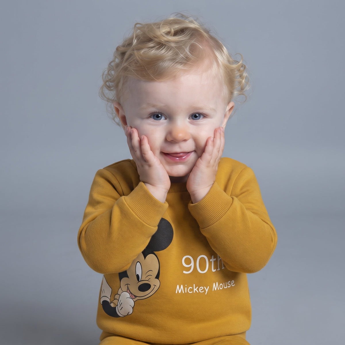 Bebé con sudadera mostaza EmpiBy de Mickey Mouse con diseño conmemorativo 90th aniversario y cuello redondo