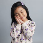Niña con sudadera EmpiBy de Minnie Mouse en color lila con estampado floral, ideal para un look cómodo y tierno.