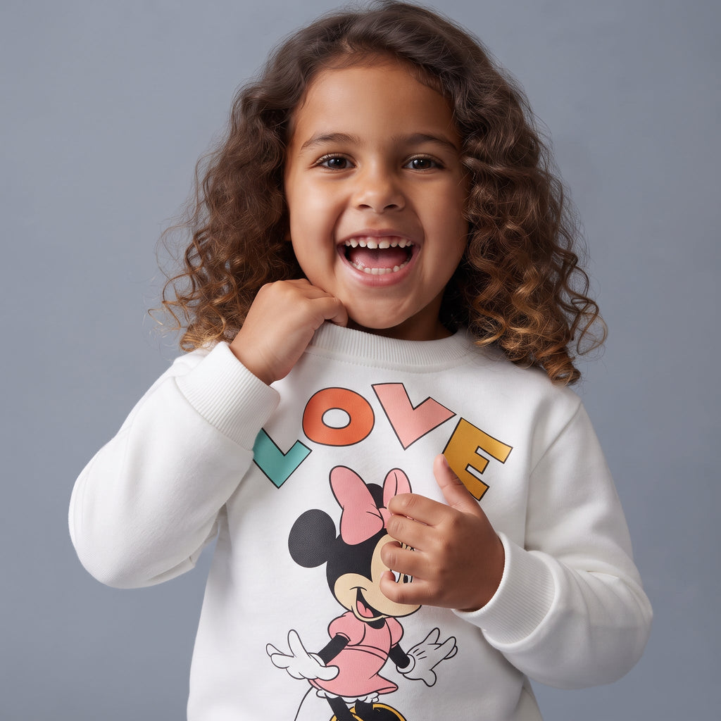 Niña sonriente vistiendo sudadera blanca EmpiBy con estampado de Minnie Mouse y letras coloridas de Love