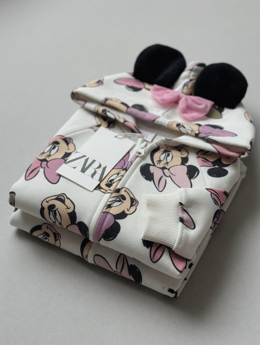 Sudadera EmpiBy con capucha de Minnie Mouse, color crema con estampado, orejas y lazo rosa en la capucha.