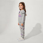 Niña sonriente vistiendo sudadera gris EmpiBy de Minnie Mouse con volantes en los hombros y pantalón a juego