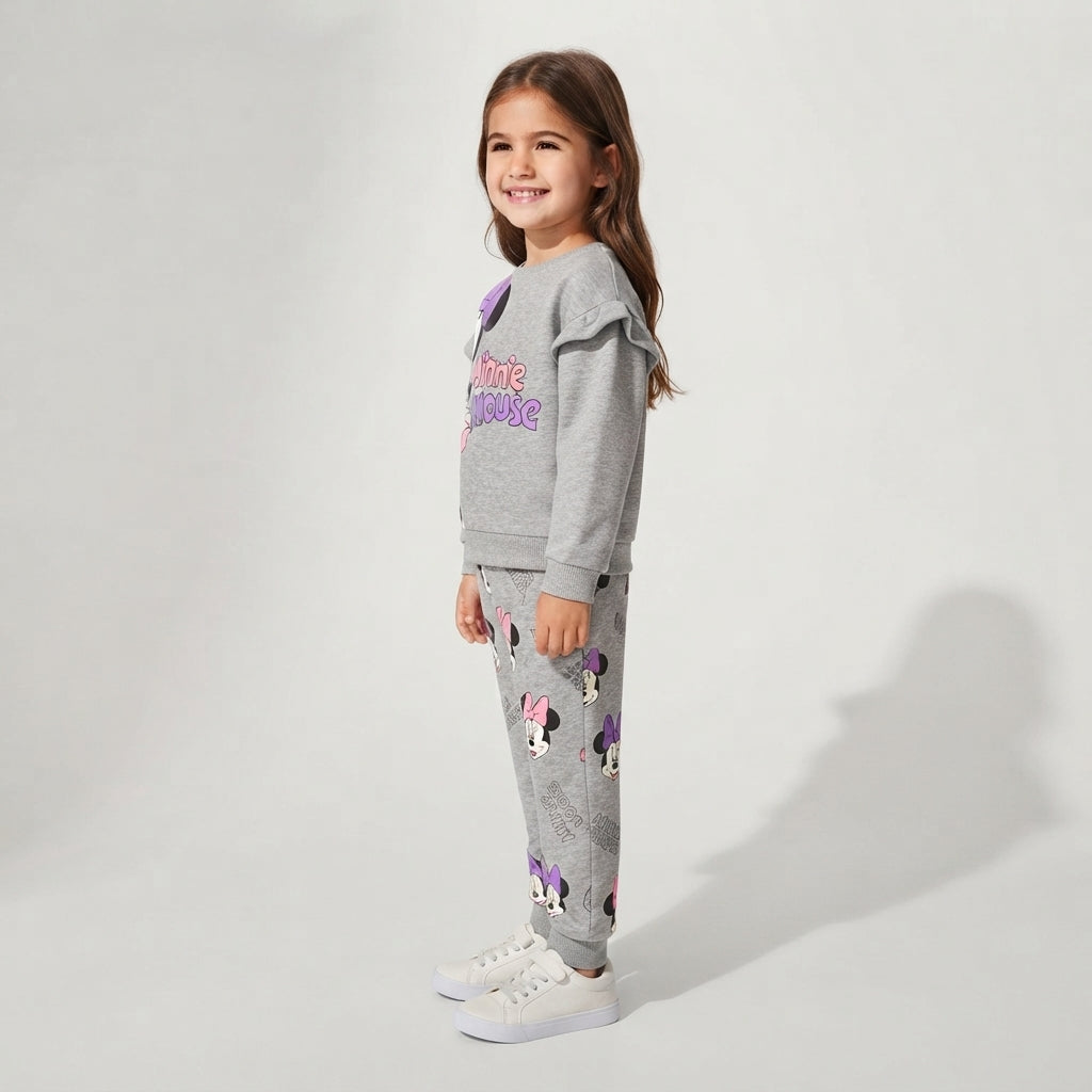 Niña sonriente vistiendo sudadera gris EmpiBy de Minnie Mouse con volantes en los hombros y pantalón a juego