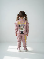 Niña de espaldas vistiendo conjunto EmpiBy de sudadera rosa con estampado de Minnie Mouse y volantes en los hombros