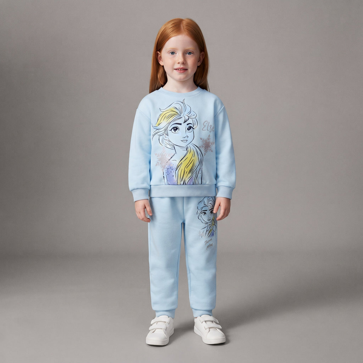 Niña pelirroja vistiendo conjunto EmpiBy de dos piezas azul claro con estampado de princesa de hielo y joggers