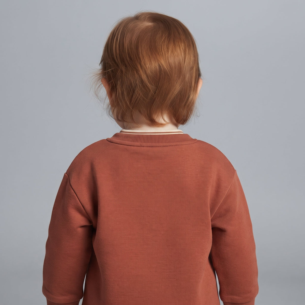 Vista trasera de niña con sudadera EmpiBy color terracota de cuello redondo y tejido suave
