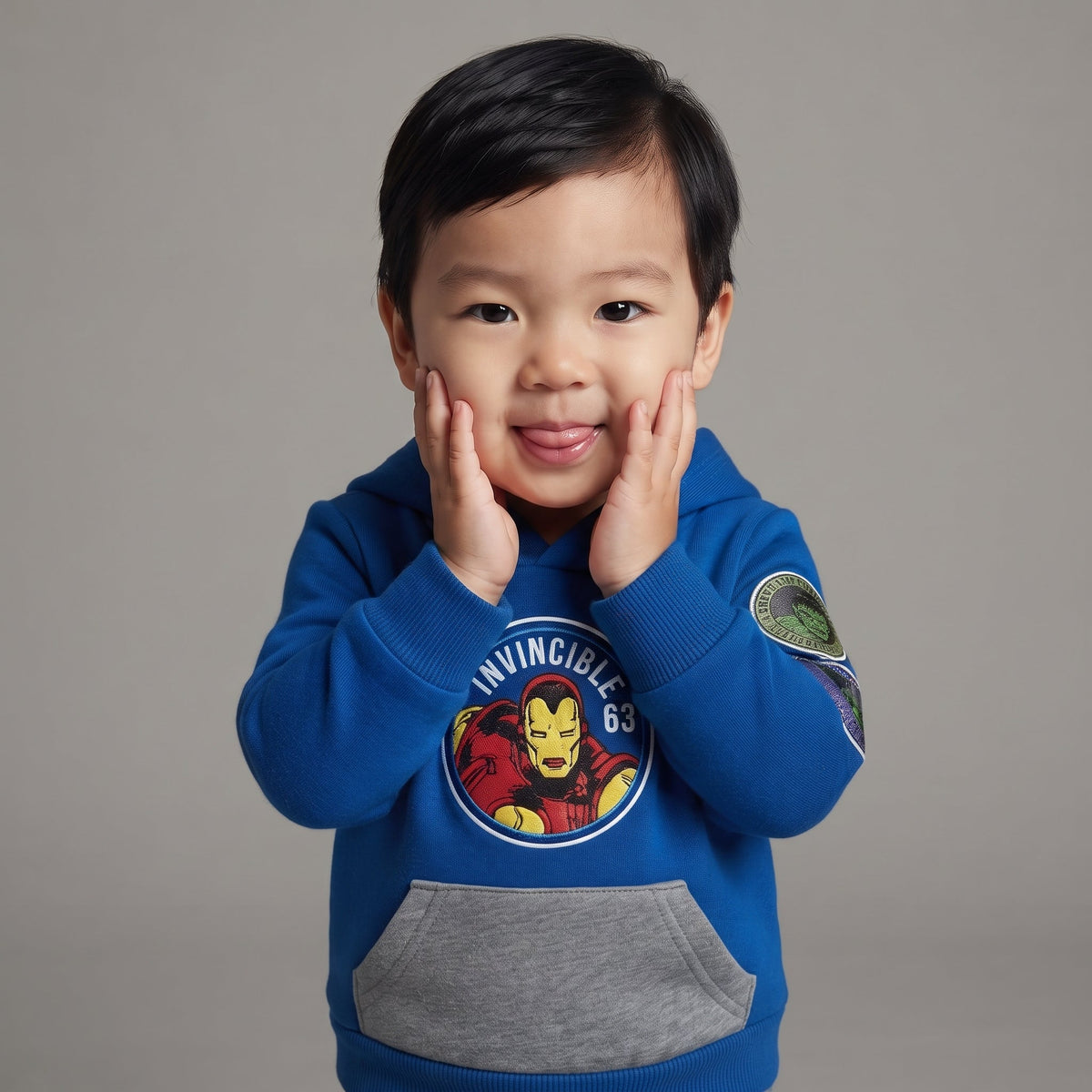 Niño pequeño sonriendo con sudadera azul EmpiBy de Iron Man con capucha y bolsillo gris frontal
