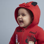 Bebé sonriente con sudadera roja EmpiBy con capucha, orejas de Minnie, lazo de lunares y estampado de Minnie y Daisy