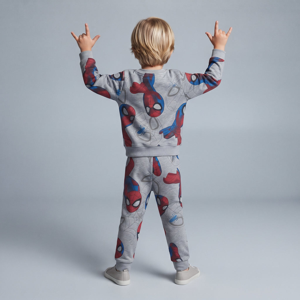 Niño de espaldas vistiendo conjunto EmpiBy de dos piezas gris de Spider-Man con estampado de máscaras y telarañas