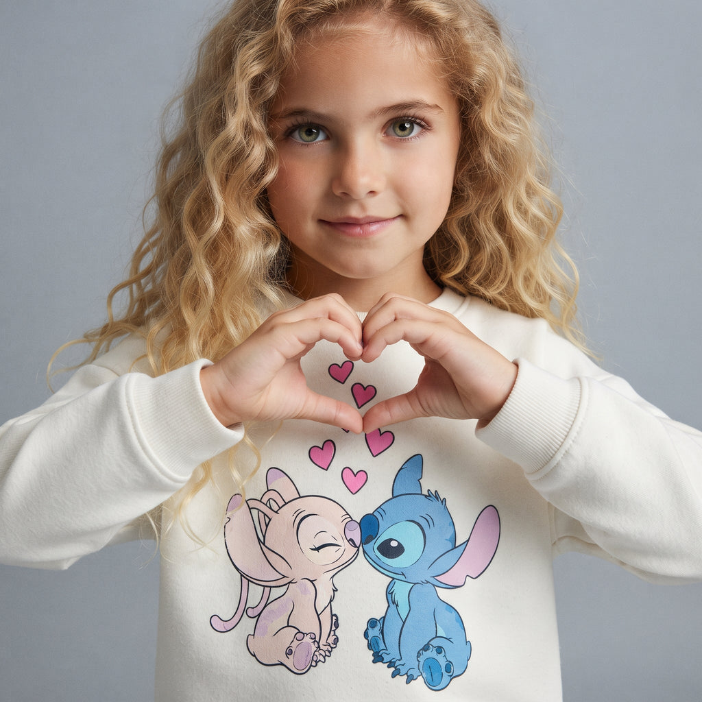 Niña con sudadera EmpiBy color hueso con estampado de Stitch y Angel besándose y corazones rosas