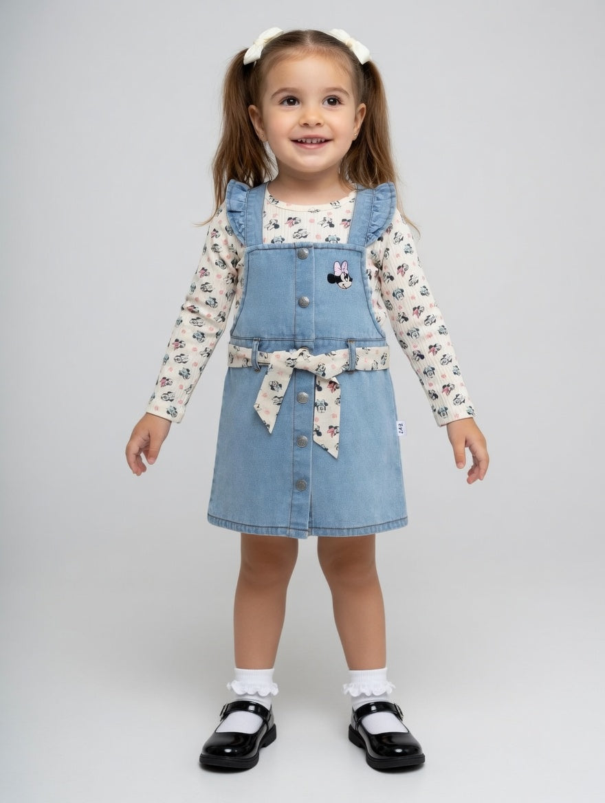Niña sonriente con conjunto EmpiBy de pichi denim azul con volantes y camiseta de manga larga estampada de Minnie Mouse