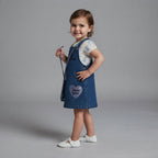 Niña vistiendo conjunto EmpiBy de vestido jardinera de mezclilla Frozen con camiseta estampada y bolso de lentejuelas