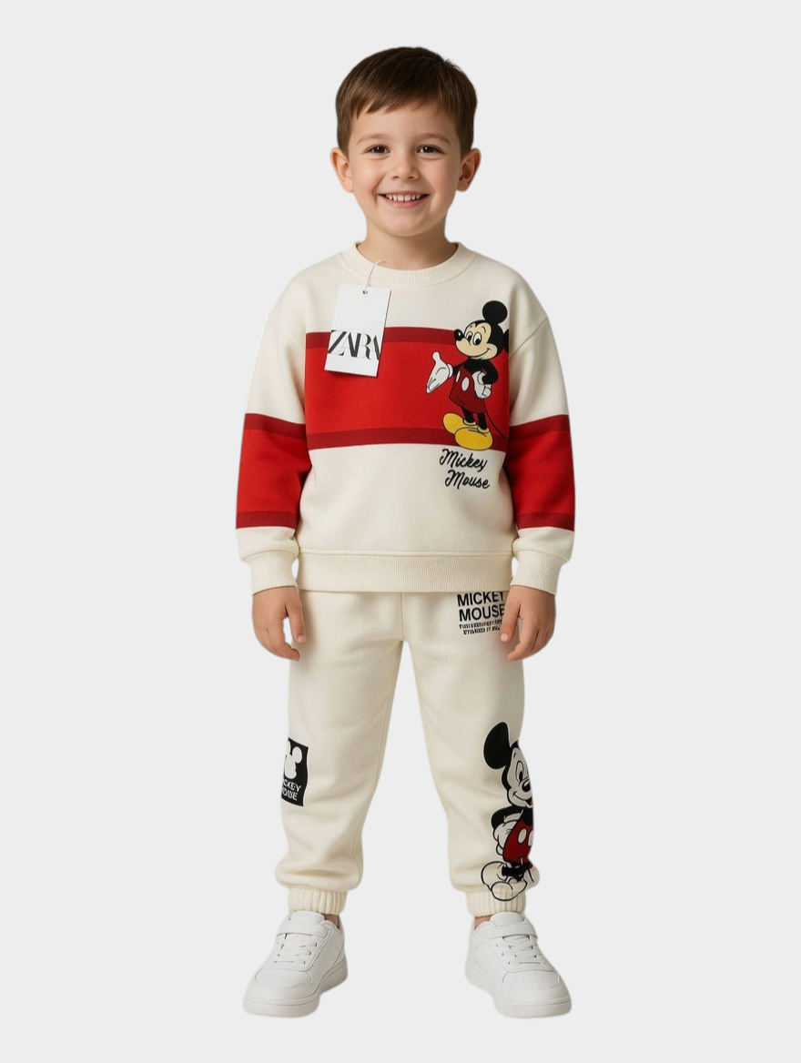 Niño sonriente vistiendo conjunto EmpiBy de sudadera y jogger crema y rojo con estampado clásico de Mickey Mouse
